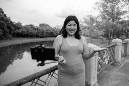 Beautiful overweight Asian woman relaxing at the park in the cityの写真素材
