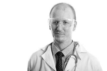 Studio shot of man doctor thinking while wearing protective glassesの写真素材
