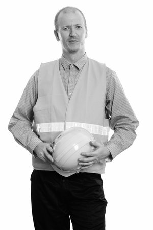 Studio shot of man construction worker holding safety helmet with both hands