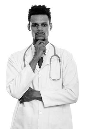 Studio shot of young African man doctor thinkingの写真素材