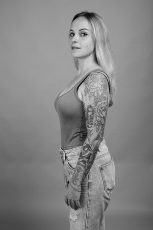 Young beautiful woman with blond hair against gray backgroundの写真素材