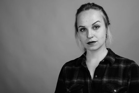Young beautiful woman with blond hair against gray background