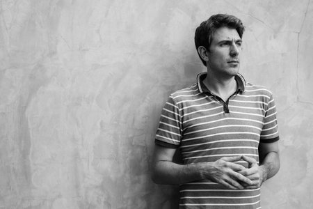 Handsome man with blond hair against concrete wall in the streets outdoorsの写真素材