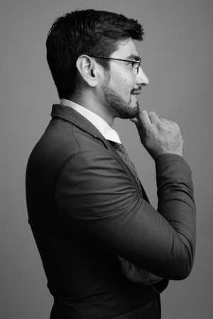 Young handsome bearded Persian businessman wearing eyeglassesの写真素材