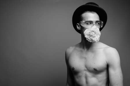Young handsome man shirtless against gray backgroundの写真素材
