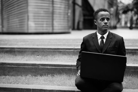 Young African businessman in suit exploring the city