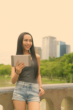 Young beautiful Asian woman relaxing at the park