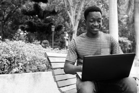 Young handsome African man relaxing at the park
