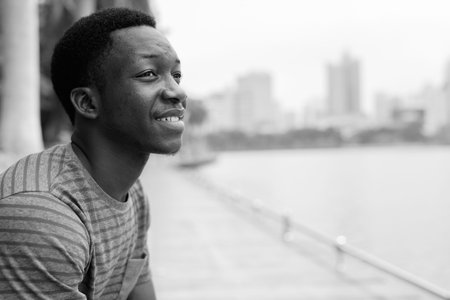 Young handsome African man relaxing at the park