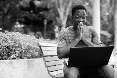 Young handsome African man relaxing at the park