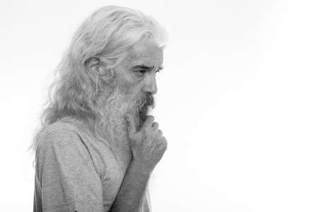 Profile view of senior bearded man thinking with hand on chinの写真素材