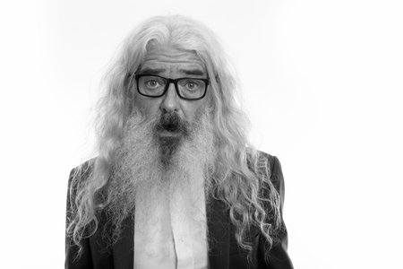 Close up of senior bearded businessman wearing eyeglasses while looking shocked