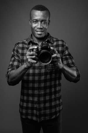 Studio shot of young African hipster man against gray backgroundの写真素材