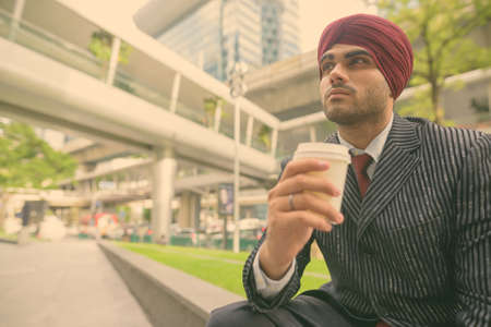 Young handsome Indian Sikh businessman wearing turban while exploring the cityの写真素材
