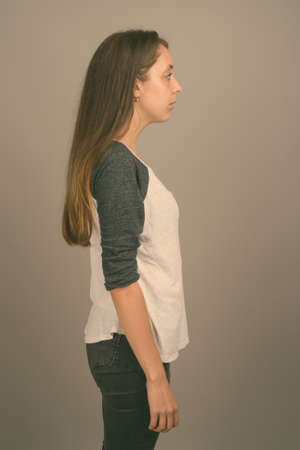 Portrait of young beautiful woman against gray backgroundの写真素材
