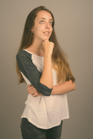 Portrait of young beautiful woman against gray background
