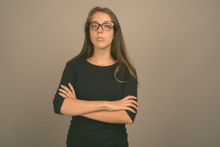 Portrait of young beautiful woman against gray background