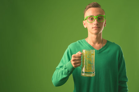 Studio shot of young handsome man against green background