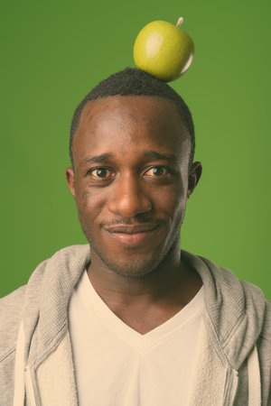 Studio shot of young African man against green backgroundの写真素材
