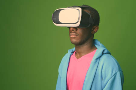 Studio shot of young African man against green backgroundの写真素材