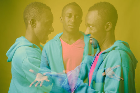 Studio shot of young African man against green background