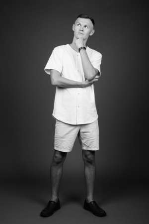 Young man wearing white shirt against gray backgroundの写真素材