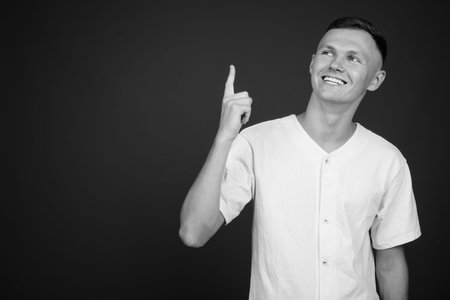 Young man wearing white shirt against gray background