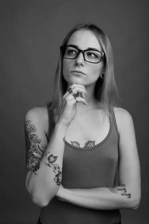 Young beautiful rebellious woman with dyed hair against gray backgroundの写真素材