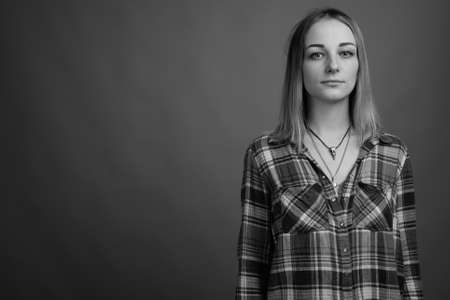 Young beautiful rebellious woman with dyed hair against gray backgroundの写真素材