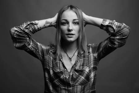 Young beautiful rebellious woman with dyed hair against gray backgroundの写真素材