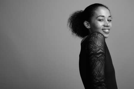 Young beautiful African woman against gray backgroundの写真素材