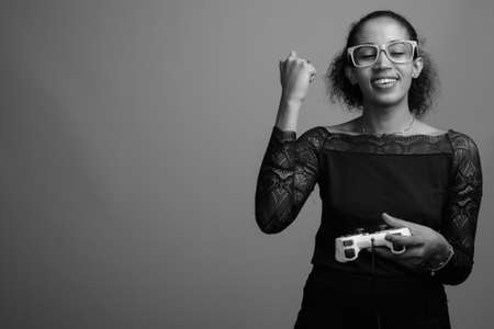 Young beautiful African woman against gray backgroundの写真素材