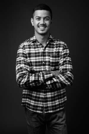 Young multi ethnic Asian man against gray backgroundの写真素材