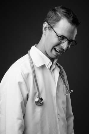 Studio shot of man doctor against gray backgroundの写真素材