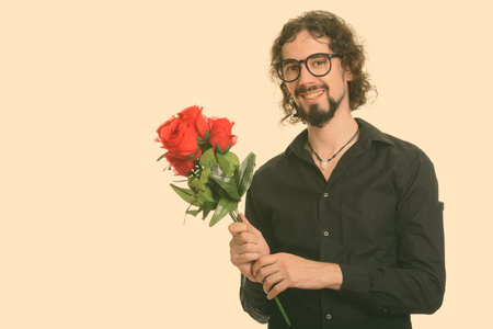 Happy handsome Caucasian man holding red roses ready for Valentines day