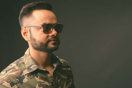 Young bearded Indian man against gray backgroundの写真素材
