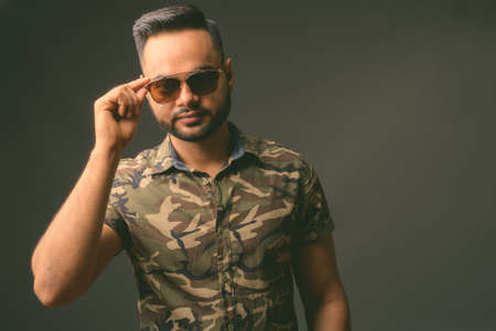 Young bearded Indian man against gray backgroundの写真素材