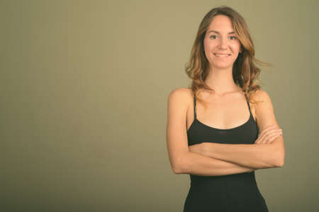 Young beautiful woman wearing sleeveless top against colored backgroundの写真素材