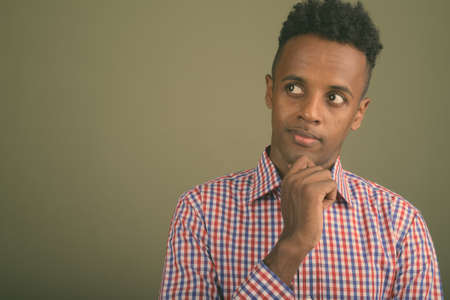 Young handsome African businessman against colored backgroundの写真素材