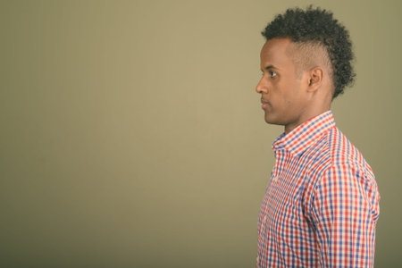 Young handsome African businessman against colored background