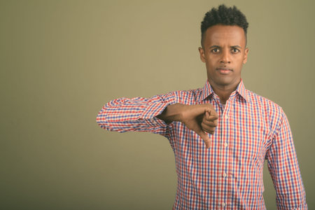Young handsome African businessman against colored background