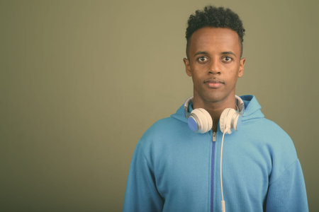 Young handsome African man wearing headphones against colored background