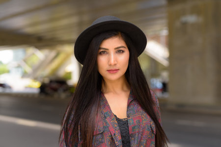 Portrait of beautiful young woman face looking at camera outdoors