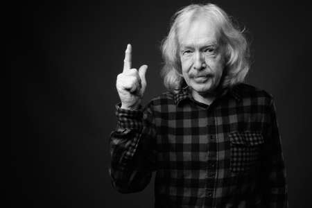 Senior man with mustache against gray backgroundの写真素材