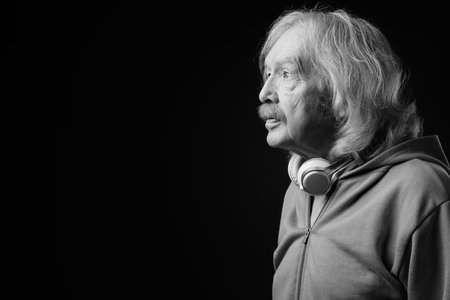 Senior man with mustache against gray background