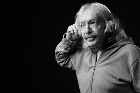 Senior man with mustache against gray backgroundの写真素材