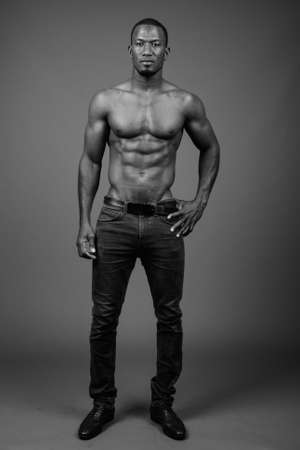 Handsome muscular African man shirtless against brown backgroundの写真素材