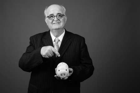 Overweight senior businessman wearing eyeglasses against brown backgroundの写真素材