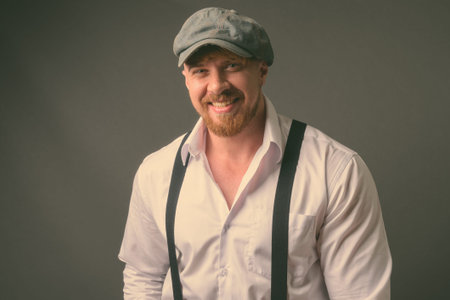Bearded man with blond hair against gray background