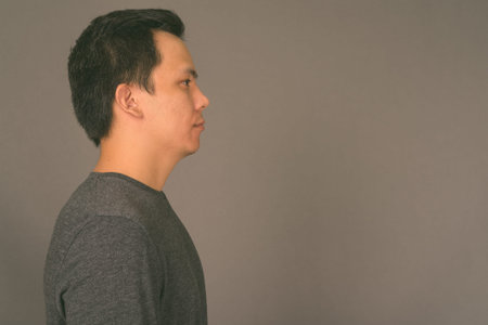 Portrait of young handsome man against gray background